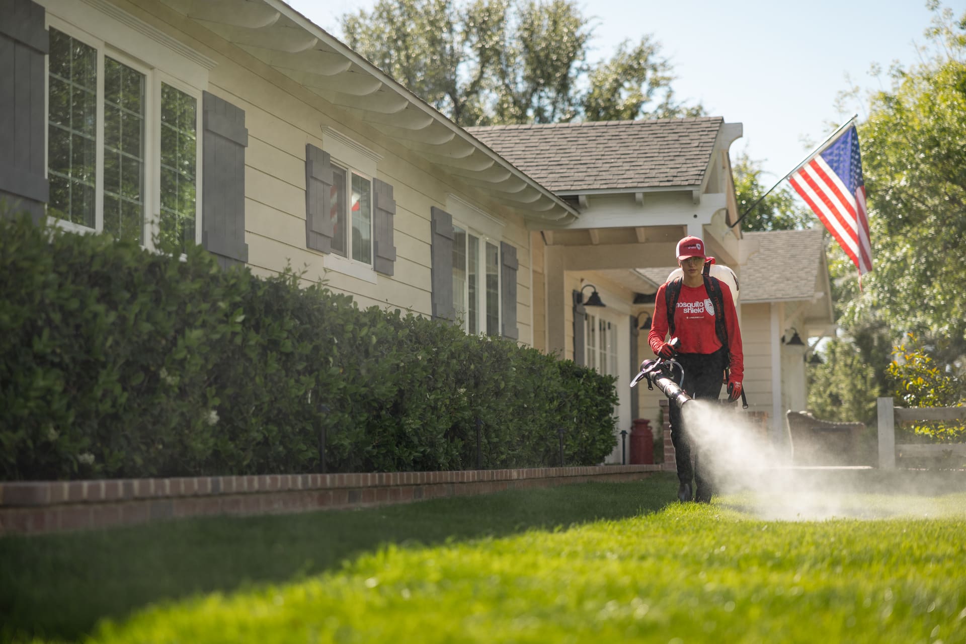 Mosquito Shield technician applying perimeter pest control treatment to South Florida home